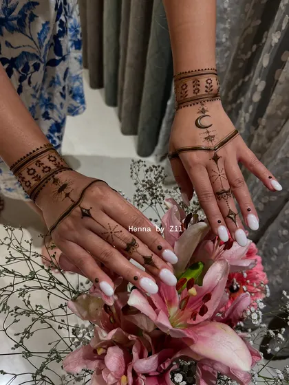 For the modern client who loves a clean aesthetic, this celestial-themed mehendi is perfect. It features delicate stars, a crescent moon, and minimalist line work on the fingers and wrist, creating a chic and contemporary look.