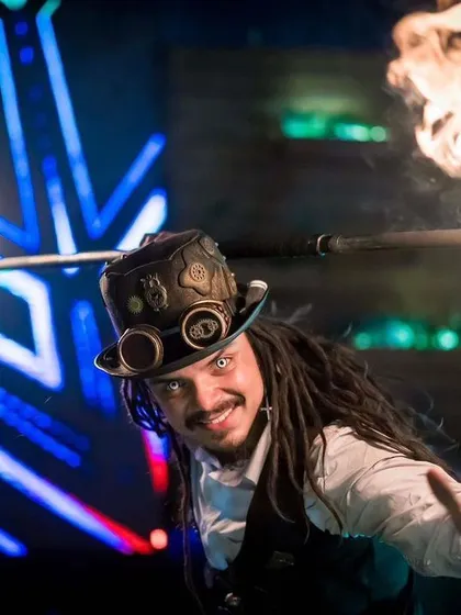 A Steampunk performer breathes fire, lighting up the stage. This classic fire skill is presented with a unique thematic twist in our Steampunk show.