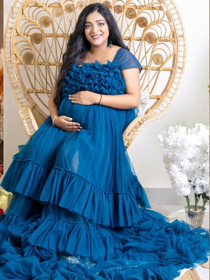 A lovely solo portrait in a stylish peacock chair. The rich blue of the gown stands out beautifully against the natural textures of the bohemian-themed set.
