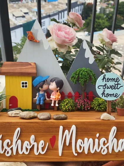 This is one of my favorite designs, capturing a sweet moment. It features a hand-painted miniature couple on a solid wood base, set against a mountain backdrop. The names are in crisp, white 3D acrylic, creating a beautiful, layered diorama that makes any entrance feel like home.