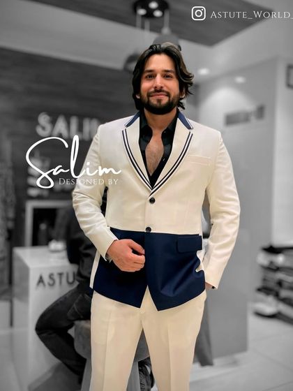 A client wearing a modern color-blocked suit in white and navy blue. This is a fashion-forward design for someone who wants to stand out.