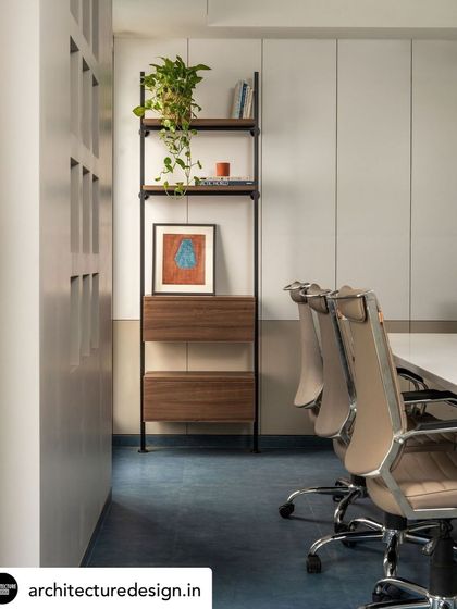 The contrast between the cool blue flooring and the warm wood of the shelving unit adds visual interest to the conference room.