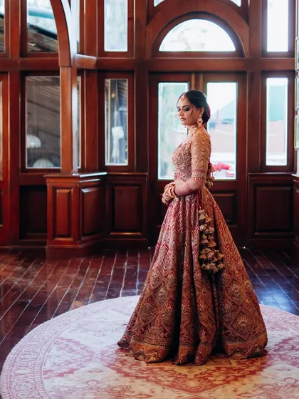 The bride in her magnificent lehenga, captured in a grand setting. The makeup was designed to feel both royal and timeless, fitting for the heritage location.