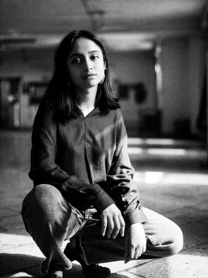 A quiet portrait in a large, empty space. The soft light and her thoughtful expression create a sense of introspection and calm.