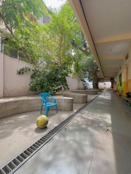 A quiet moment in the school corridor, where simple concrete forms create informal seating and play spaces for the children.