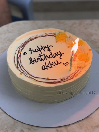 A simple and sweet personalized birthday cake, perfect for a small celebration. The lit candle shows it's ready for a wish.