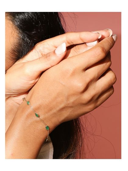 The dainty emerald bracelet worn on the wrist, showing how it drapes like a second skin. It's subtle enough for everyday wear, yet striking enough to turn heads.