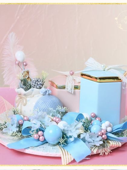 This baby boy announcement hamper is a picture of serene elegance. The soft blue ceramic jars, a delicate feather, and a tiny teddy bear create a gentle and loving welcome for the new arrival.