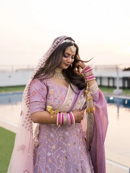 A candid moment of the bride adjusting her kalire, a small, beautiful detail of her complete bridal look.