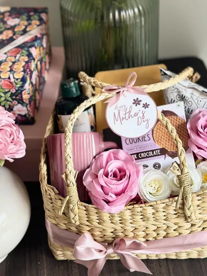 This "Basket of Love" for Mother's Day contains masala tea, makhana, a coffee mug, a Body Shop shower gel, and waffle chip cookies, all beautifully arranged in a wicker basket.
