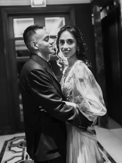 An elegant black and white portrait of a couple sharing a quiet moment. The soft lighting and their gentle embrace create a feeling of romance and intimacy.