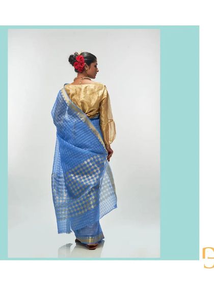 A back view of the cornflower blue saree, paired with a golden blouse that complements the zari work.