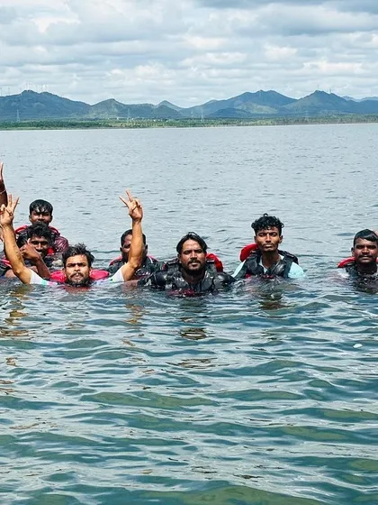 A group of participants and their instructor pose for a photo in the water, celebrating a great day of learning and fun.