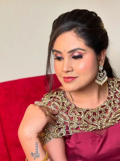 A glamorous party look for Sowmya. This features a bold smokey eye, a contoured base, and a stylish half-updo, perfect for an evening event.
