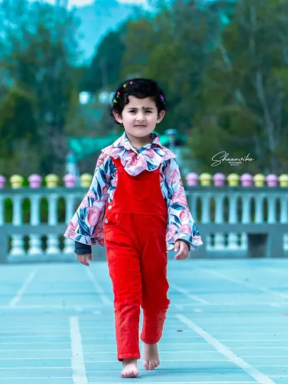 A confident stride from my daughter in a bright red outfit. This action shot captures the energy and spirit of childhood during a fun outdoor photoshoot.