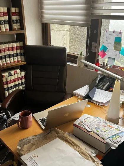 My desk setup, complete with legal books, a laptop, and endless paperwork. This is where strategies are formed and arguments are built.
