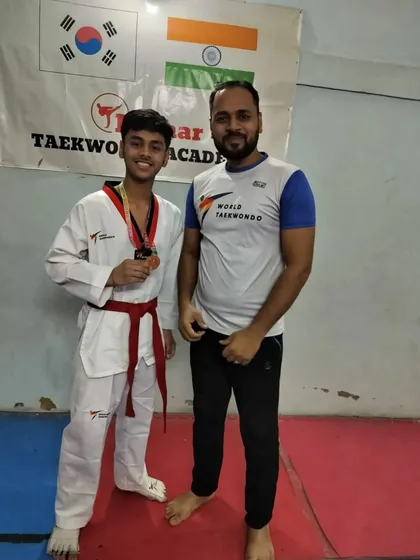 A red belt student with his bronze medal.