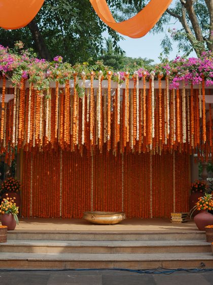 The main stage for the Haldi ceremony, completely enveloped in a curtain of fresh orange marigolds.