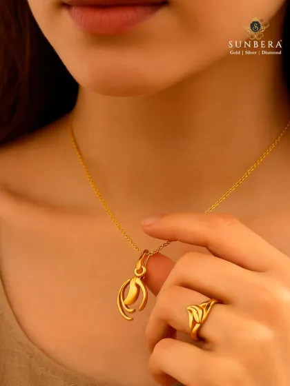 Here is a matching gold pendant and ring set, designed with a modern, abstract floral motif. Worn here by a model, you can see how the clean lines and polished finish create an look of understated elegance.