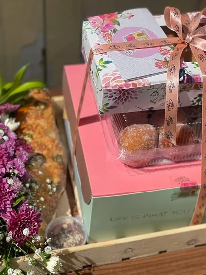 A sweet-focused custom hamper, featuring a box of my Italian stuffed donuts, a savoury pull-apart bread, and a small floral arrangement. It's a perfect gift for someone with a sweet tooth.