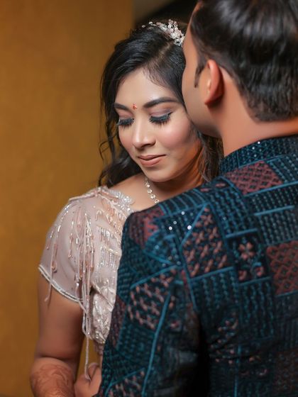 An intimate over the shoulder shot of the couple. The focus is on the bride's serene expression as the groom leans in close, capturing a quiet moment of affection.