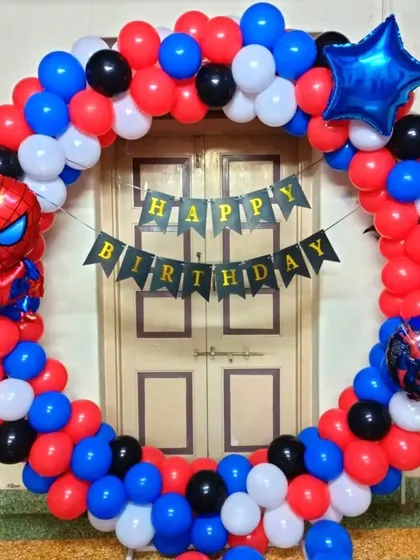 A Spiderman themed balloon ring decoration for a home birthday party. This is a great option for a photo backdrop, using character foil balloons and a 'Happy Birthday' banner.