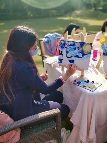 Another artist at work during our sunny, outdoor painting event, adding her personal touch to the iconic swirling sky.