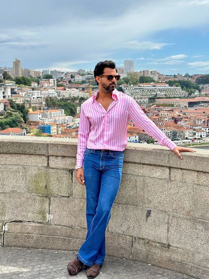 Paired with flared denim, the pink candy stripe shirt creates a stylish, retro-inspired ensemble that is both comfortable and eye-catching.