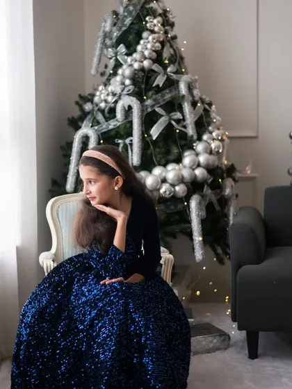A wider shot of this Disney princess moment. The sparkling blue dress against the festive backdrop makes for a stunning and memorable Christmas portrait.