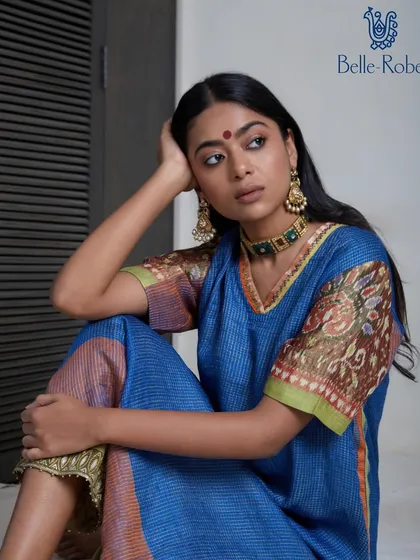 A thoughtful portrait showcasing a beautiful blue printed kurta. The makeup is soft and natural, with a touch of kohl to define the eyes and a traditional bindi, creating a look of effortless grace.