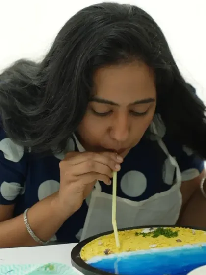 A participant uses a straw to create wave effects in her resin beach art. This is a fun and effective technique we teach in the workshop.