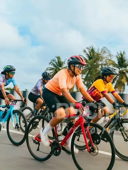 The women's peloton against a backdrop of palm trees during the Nandi Epic. The scenery is almost as breathtaking as the racing.