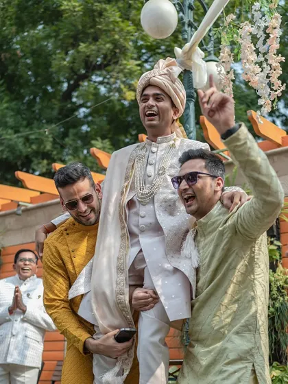 The groom being lifted up by his friends during the baraat. A moment of pure celebration at this intimate Delhi wedding.