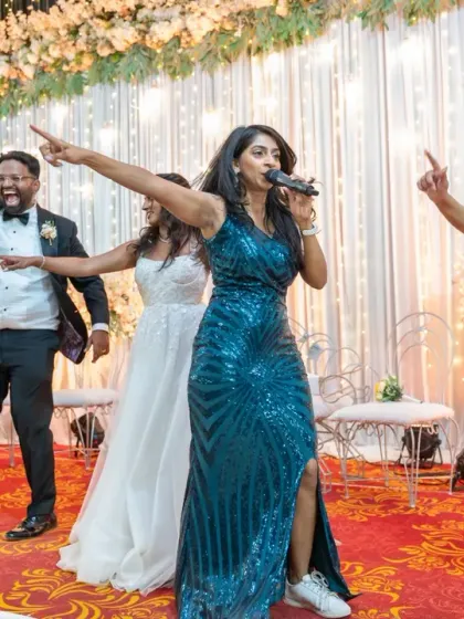 The wedding party, led by the emcee, performs a fun dance routine on stage. It’s a great candid shot of the bride, groom, and their friends enjoying the moment.