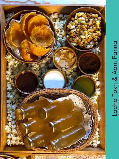 A unique offering for summer parties, this platter includes Lacha Tokri chaat and refreshing homemade Aam Panna served in charming glass bottles.