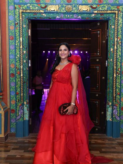 A full-length shot of Payal's stunning one-shoulder red organza gown, designed to make a statement.