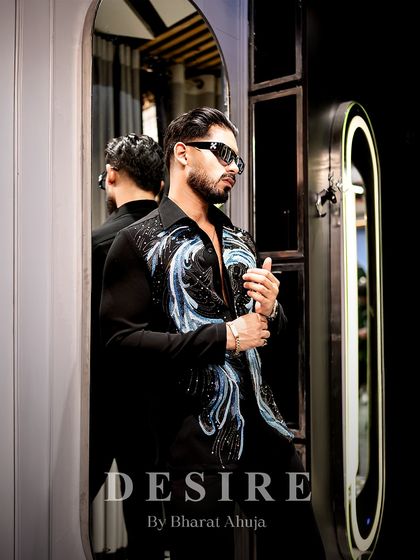 A reflection of style. This image captures the shirt's intricate design and the wearer's cool confidence, a perfect match of man and garment.
