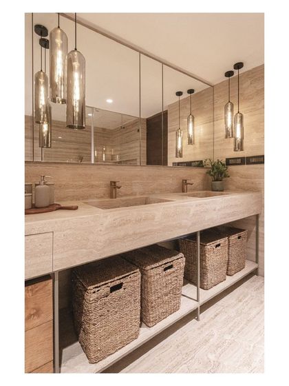 The warm glow from the pendant lights reflects in the large mirror, making the master bath feel spacious and inviting.