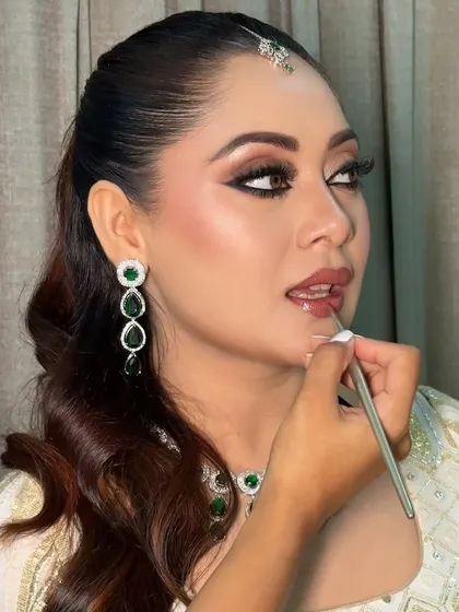 The final step in perfecting a Nikkah look. I am applying a natural, glossy lip color to complement the bride's defined kohl eyes and dewy skin.