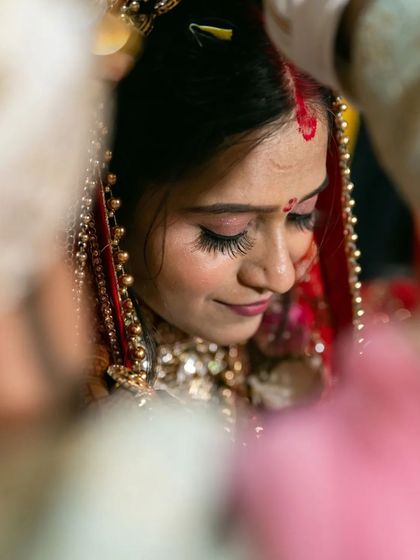 The sacred moment of applying the sindoor. This close up shot is full of emotion and tradition, focusing on the bride's serene expression.