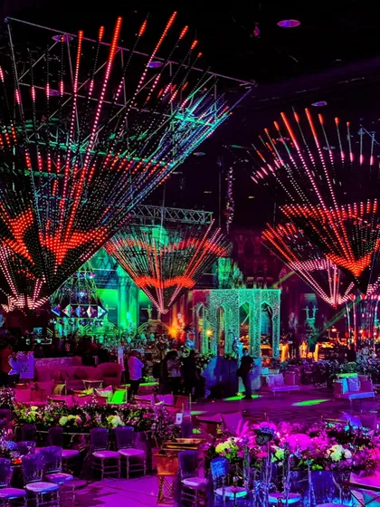 An electrifying Sangeet night with kinetic light installations. The dynamic red and green lights created a vibrant, pulsating energy that matched the excitement of the evening.