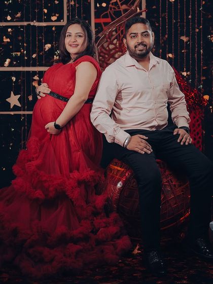 A festive couple's portrait featuring our red tiered tulle gown. The rich color and voluminous design make it a great option for holiday-themed or celebratory maternity photoshoots.
