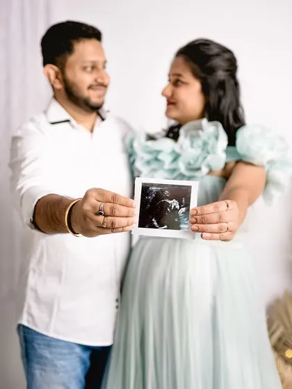 A happy couple holding up their baby's first ultrasound picture. This is a heartwarming way to announce a pregnancy and is a popular shot in my studio maternity sessions.