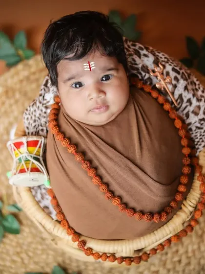 A slightly different angle of the Shiva-themed shoot, capturing the baby's calm expression.