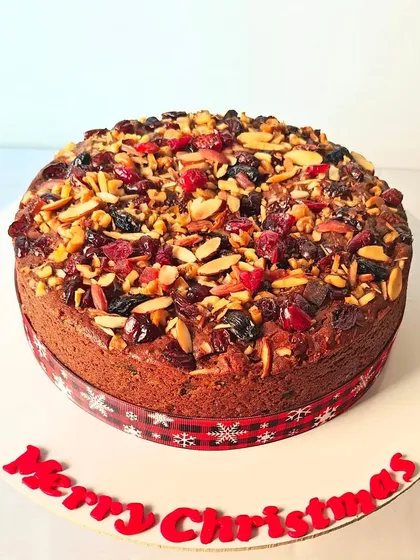 My traditional Christmas plum cake is a labor of love. It's incredibly rich and dense, packed with rum-soaked fruits and topped with a generous layer of toasted almonds and dried berries for a festive finish.