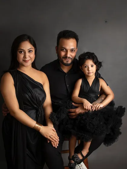 A classic family portrait with a timeless feel. Coordinated outfits against a dark, elegant backdrop create a sophisticated look that you will treasure forever as a family heirloom.