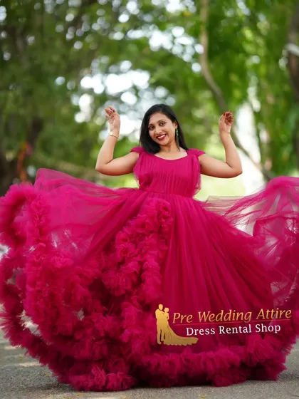 A joyful, candid shot showing the movement and volume of the magenta ruffled gown. This dress is not only beautiful but also fun to wear, allowing for playful and happy maternity photos.