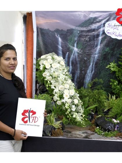 A graduating student from our Pune branch with her final masterpiece. Her project, a stunning waterfall of white flowers, demonstrates a sophisticated understanding of flow, texture, and large-scale design.
