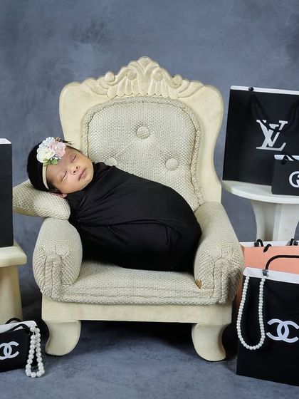 A touch of glamour for this little fashionista. This fun, high-fashion theme uses miniature designer-inspired shopping bags for a playful and stylish newborn portrait.