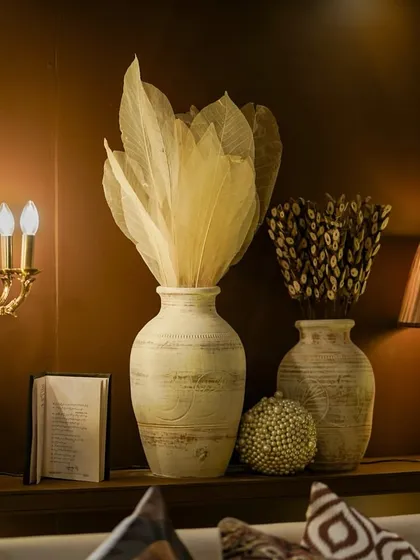 A corner detail from the lounge area, featuring a vintage candelabra, textured vases, and dried arrangements that create a sophisticated, library-like feel.